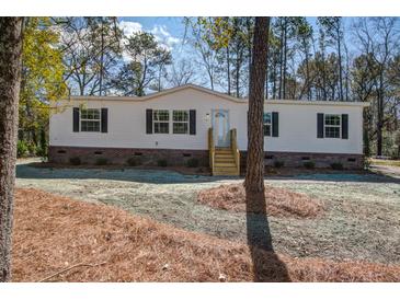 Well-maintained white single-story home with black shutters, wooden steps, and a freshly mulched yard at 421 Peacock Ln, Summerville, SC 29486