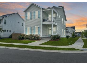 Charming two-story home with a covered porch, light blue shutters, and manicured landscaping creating curb appeal at 500 W Respite Ln, Summerville, SC 29483