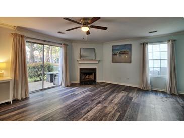 Bright living room featuring a fireplace, ceiling fan and sliding glass door to outdoor space at 6211 Rolling Fork Rd. # 1504 Apt D, North Charleston, SC 29406