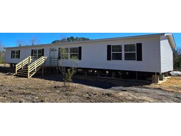 Charming single-story home featuring vinyl siding, black window shutters, and a new wooden staircase and porch at 632 Dennis Ridge Rd, Bonneau, SC 29431