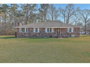 Charming brick ranch-style home with a well-manicured lawn and mature trees, offering classic curb appeal at 1186 French Santee Rd, Jamestown, SC 29453