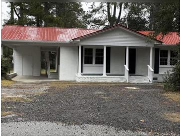 Charming one-story home featuring a red metal roof, white painted brick, and a convenient carport at 201 Hayden St St, Walterboro, SC 29488