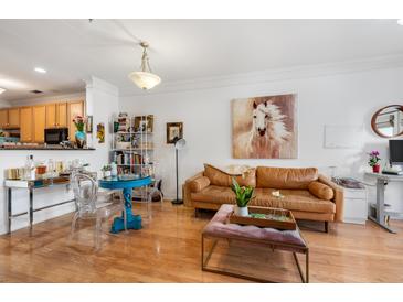 Bright living room features hardwood floors, a tan leather sofa, and an open floor plan at 2244 Ashley Crossing Dr # 426, Charleston, SC 29414