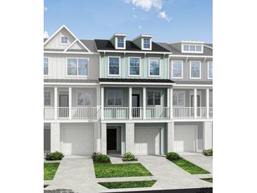 Charming two-story townhouse with a porch, garage, and manicured lawn at 414 Katies Scenic Ct, Charleston, SC 29492