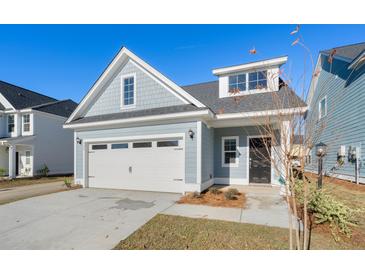 Charming home with a white garage door, blue siding, and a well-maintained front yard on a clear day at 417 Grove End Rd, Moncks Corner, SC 29461