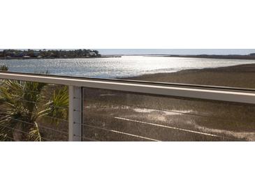 Relaxing balcony view with marsh and water views through a screen porch with stainless steel cable railing system at 102 Mariners Cay Dr, Folly Beach, SC 29439