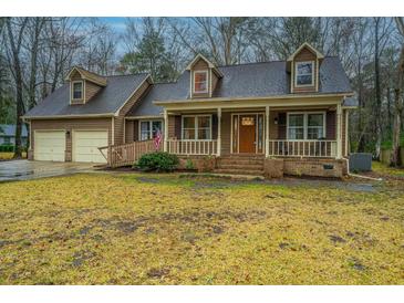 Charming two-story home with a welcoming front porch, well-manicured yard, and attached two-car garage at 112 Ravenswood Ct, Summerville, SC 29485