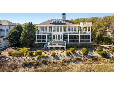 Expansive two-story coastal home with multiple balconies and screened-in porches overlooking the manicured dunes at 1136 Ocean Forest Ln, Seabrook Island, SC 29455