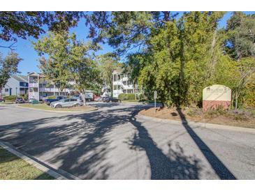 Brigadier Condominiums exterior view highlighting well-maintained grounds, lush trees, and beautiful landscaping on a sunny day at 1530 Fort Johnson Rd # 3C, Charleston, SC 29412