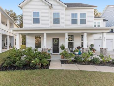 Charming front porch with rocking chair, lush plants, and welcoming curb appeal at 217 Woodland Oak Way, Summerville, SC 29485