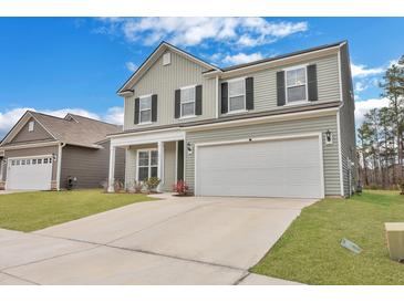 Charming two-story home with a welcoming front yard and a two-car garage, enhanced by black shutters and updated siding at 231 Hayworth Rd, Summerville, SC 29486