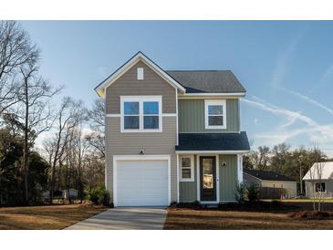 Charming two-story home features a covered front entry, attached garage, and neutral two-tone siding at 6273 Ballpark Rd Rd, Hollywood, SC 29449