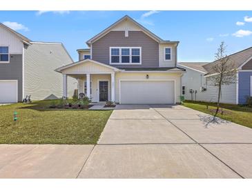 Charming two-story home featuring a two-car garage and manicured front lawn at 4497 Ocean Farm Dr, Summerville, SC 29485