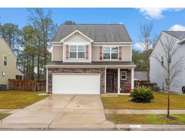 Charming two-story home featuring a stone facade, two-car garage, and a well-manicured front yard at 558 Wynfield Forest Dr, Summerville, SC 29485
