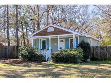 Charming cottage-style home with a cozy front porch, blue shutters, and a well-maintained yard at 716 W 3Rd N St, Summerville, SC 29483