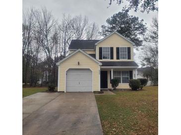 Charming two-story home with yellow siding, black shutters, and a well-maintained front yard at 9044 Greenbriar Dr, Summerville, SC 29485