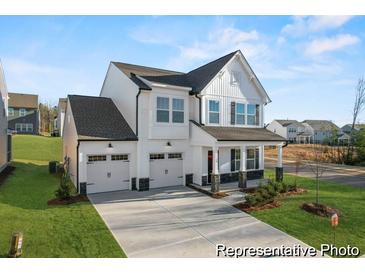 Charming two-story home with white siding, black accents, two-car garage, and well-manicured front lawn at 1022 Drakeford St # 10P, Saint George, SC 29477