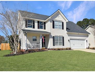 Charming two-story home with vinyl siding, a well-manicured lawn, and an attached two car garage at 107 Hainsworth Dr, North Charleston, SC 29418