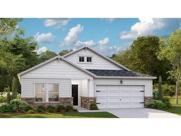 Charming single-story home featuring stone accents, white siding, a two-car garage, and beautifully landscaped front yard at 1173 Darling St, Summerville, SC 29485