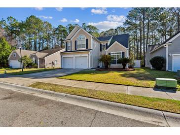 Charming two-story home featuring a manicured lawn, two-car garage, and inviting curb appeal at 1452 Water Edge Dr, Charleston, SC 29492