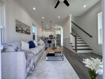 Bright living room boasts modern decor, a cozy couch, and an open floor plan leading to the kitchen at 2012 Forest Ave, North Charleston, SC 29405