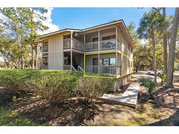 Inviting condo exterior showcasing a private deck nestled among lush greenery and mature trees at 214 Sea Cloud Cir, Edisto Island, SC 29438
