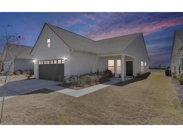 Charming home with a well-manicured lawn, attached garage, and inviting front porch at 220 Garden Gate Way, Summerville, SC 29486