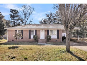 Charming single-story brick home featuring a white front door and manicured landscaping at 2236 Pinehurst Ave, Charleston, SC 29414