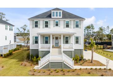 Stunning two-story home features white siding, sage shutters, and an inviting front porch with marsh views at 3554 Clambank Dr, Mount Pleasant, SC 29466