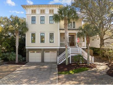 Stunning three-story home with a beautiful brick driveway, two-car garage, and lush tropical landscaping at 4008 Cameron Blvd, Isle of Palms, SC 29451