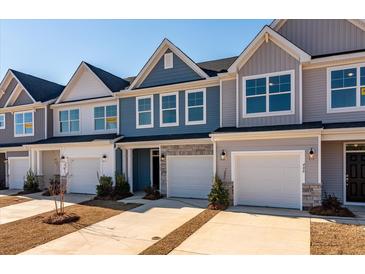 Charming townhomes feature stone accents, attached garages, and well-manicured landscaping at 416 Duskywing Dr, Goose Creek, SC 29445