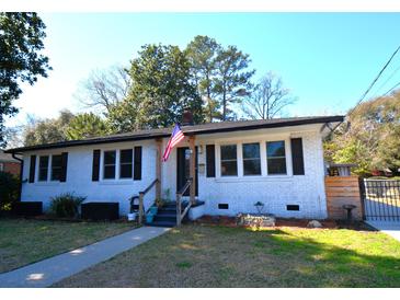 Charming white brick home with black shutters, American flag, and well-manicured lawn at 5273 Potomac St, North Charleston, SC 29405