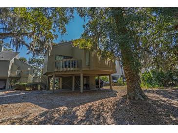 Charming raised beach house with wooden deck and shaded parking beneath the home at 601 Magnolia Ln, Edisto Island, SC 29438