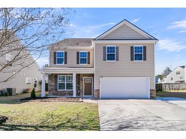 Charming two-story home featuring stone accents, neutral siding, and a well-manicured front lawn under a clear blue sky at 105 Endicott Ct, Summerville, SC 29486