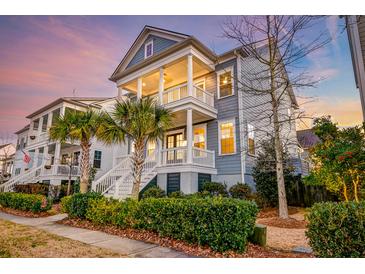 Charming two-story home with double porches, palm trees, manicured landscaping, and inviting curb appeal at 1625 Oak Leaf St, Daniel Island, SC 29492
