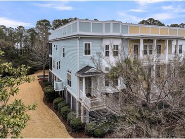 Charming multi-story townhome with colorful accents, manicured landscaping, and a welcoming front porch at 2032 Amenity Park Dr, Mount Pleasant, SC 29466