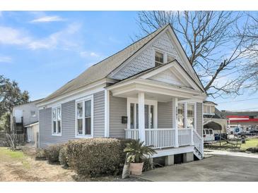 Charming grey home with white trim, a welcoming front porch, and well-maintained landscaping at 2097 Mt Pleasant St, Charleston, SC 29403
