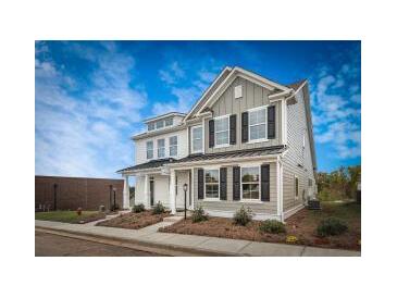 Charming two-story home with black shutters, landscaped yard, and a bright blue sky at 209 Abercom Place Dr, Moncks Corner, SC 29461