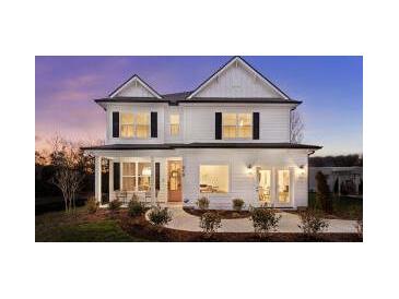 Charming two-story home with a welcoming front porch and manicured landscaping at dusk at 325 Abercom Place Dr, Moncks Corner, SC 29461