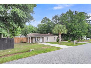Charming single-story home with lush lawn, long driveway, and a classic, quaint curb appeal at 3316 Island Estates Dr, Johns Island, SC 29455