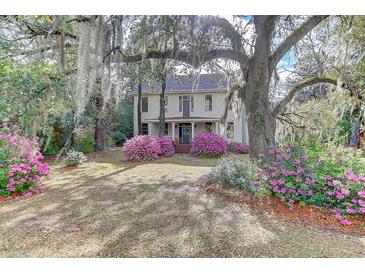 Charming two-story home featuring beautiful landscaping and mature trees draped with Spanish moss at 408 N Parler Ave, Saint George, SC 29477