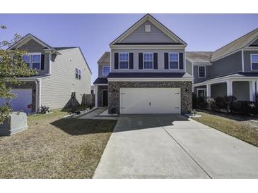 Charming two-story home featuring a brick facade and a two-car garage with a long driveway at 762 Redbud Ln, Summerville, SC 29486