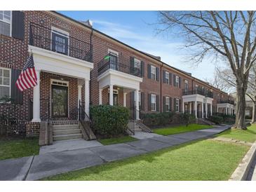 Charming brick townhomes featuring manicured lawns and inviting entrances on a sunny day at 871 Center Park St, Charleston, SC 29492