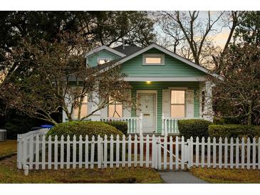 Charming home exterior featuring a picket fence, tidy landscaping, and a cozy covered porch at 103 Tall Oak Ave, Charleston, SC 29407