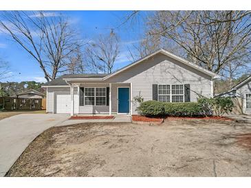 Charming single-story home featuring light gray siding, black shutters, and a vibrant blue front door at 106 Equestrian Ct, Summerville, SC 29486