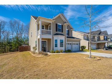 Charming two-story home featuring a covered porch, two-car garage, and well-maintained lawn at 1273 Discovery Dr, Ladson, SC 29456