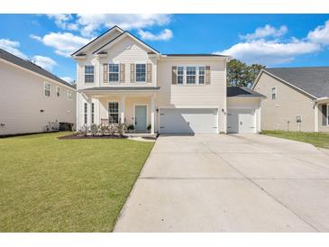 Charming two-story home with a well-manicured lawn, inviting porch, and three-car garage at 130 Wappoo Trace Ln, Summerville, SC 29486