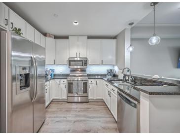 Bright kitchen features stainless steel appliances, granite countertops, and white cabinets at 135 Pier View St # 203, Charleston, SC 29492