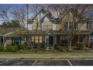 Inviting townhome exterior with a charming front porch and well-maintained landscaping for curb appeal at 7977 Shadow Oak Dr, North Charleston, SC 29406