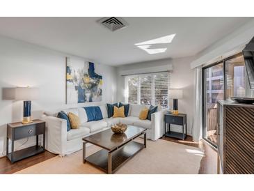 Bright living room featuring a white couch, stylish decor, and sliding glass doors to a deck at 9000 Palmetto Dr # G-302, Isle of Palms, SC 29451